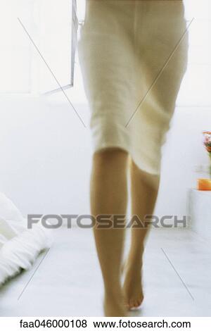 Woman wearing skirt walking barefoot across room, low section View Large Photo Image Stock Photo - Woman wearing skirt walking barefoot across room, low section. Fotosearch