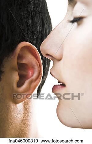 Woman with eyes closed whispering in man's ear, close-up View Large Photo Image Stock Photo - Woman with eyes closed whispering in man's ear, close-up. Fotosearch