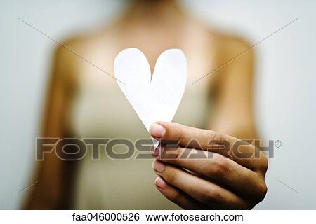 Stock Photograph - Woman's hand holding out paper heart. Fotosearch
