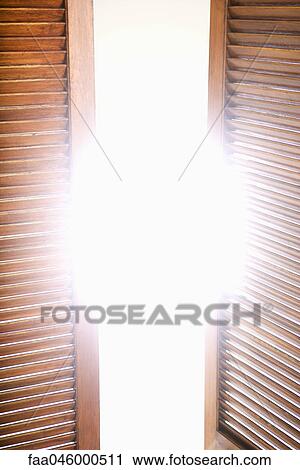 Wooden shutters partially opened to bright sunlight View Large Photo Image Stock Image - Wooden shutters partially opened to bright sunlight. Fotosearch