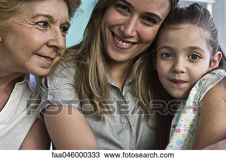 Stock Image - Young girl with mother and grandmother, portrait. Fotosearch