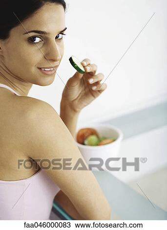 Young woman eating sliced raw vegetables View Large Photo Image Stock Image - Young woman eating sliced raw vegetables. Fotosearch