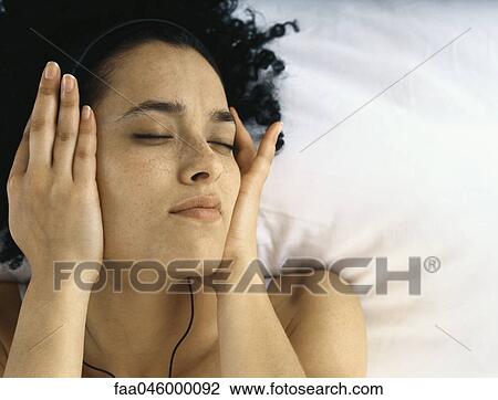 Young woman listening to headphones, eyes closed View Large Photo Image Stock Image - Young woman listening to headphones, eyes closed. Fotosearch
