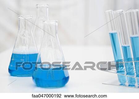 Stock Image - Beakers, test tubes containing blue liquid. Fotosearch