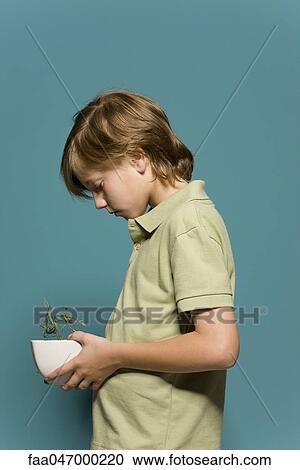 Boy holding wilted potted plant, head down View Large Photo Image Stock Image - Boy holding wilted potted plant, head down. Fotosearch