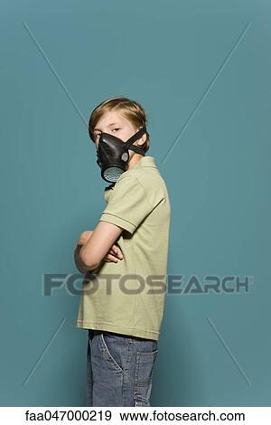 Boy wearing gas mask, arms folded, looking over shoulder at camera View Large Photo Image Stock Photo - Boy wearing gas mask, arms folded, looking over shoulder at camera. Fotosearch