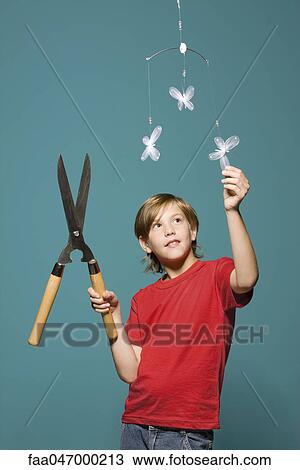 Boy with hedge clippers looking up at butterfly mobile View Large Photo Image Stock Image - Boy with hedge clippers looking up at butterfly mobile. Fotosearch