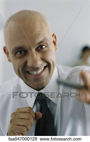 Stock Photo - Businessman clenching fists, smiling at camera. Fotosearch