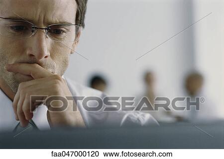 Businessman looking at computer screen with concern View Large Photo Image Stock Image - Businessman looking at computer screen with concern. Fotosearch