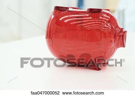 Stock Image - Coins in upside down piggy bank. Fotosearch