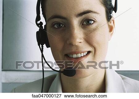 Customer service representative wearing headset, smiling at camera View Large Photo Image Stock Photo - Customer service representative wearing headset, smiling at camera. Fotosearch