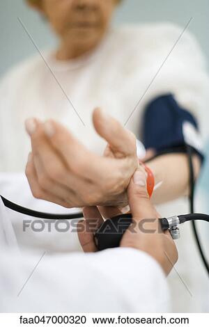 Doctor checking patient's blood pressure, cropped View Large Photo Image Stock Image - Doctor checking patient's blood pressure, cropped. Fotosearch