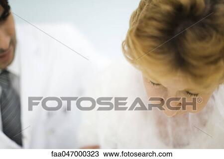 Stock Image - Doctor examining female patient. Fotosearch