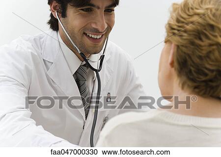 Stock Image - Doctor examining patient with stethoscope. Fotosearch