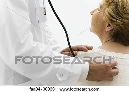 Stock Image - Doctor listening to patient's back with stethoscope, cropped. Fotosearch