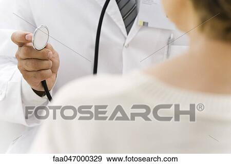 Doctor preparing to examine patient using stethoscope View Large Photo Image Stock Photo - Doctor preparing to examine patient using stethoscope. Fotosearch