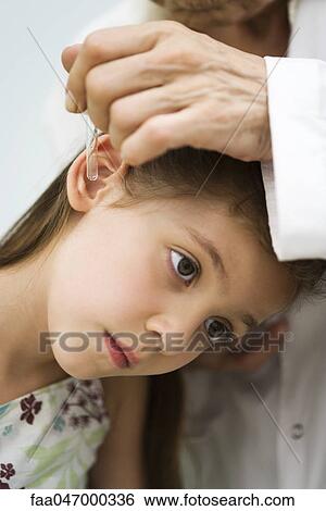 Doctor putting drops in little girl's ear, cropped View Large Photo Image Stock Photograph - Doctor putting drops in little girl's ear, cropped. Fotosearch