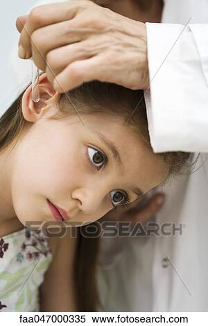 Stock Photography - Doctor putting drops in little girl's ear, cropped. Fotosearch