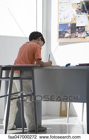 Elementary school student doing assignment in classroom View Large Photo Image Stock Image - Elementary school student doing assignment in classroom. Fotosearch