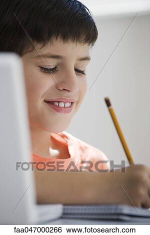 Stock Photograph - Elementary school student writing classwork. Fotosearch