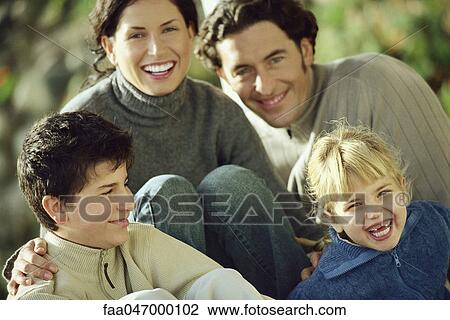 Stock Image - Family laughing together outdoors. Fotosearch