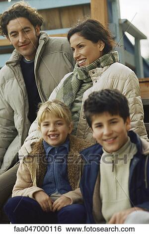 Stock Photograph - Family sitting together on deck. Fotosearch
