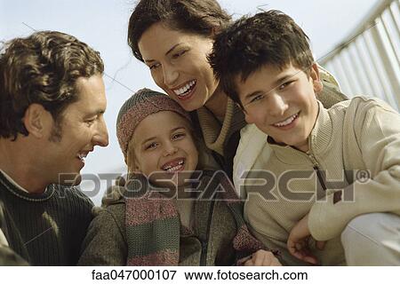 Stock Photo - Family smiling together outdoors. Fotosearch