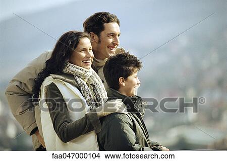 Picture - Family standing together outdoors, looking at view. Fotosearch