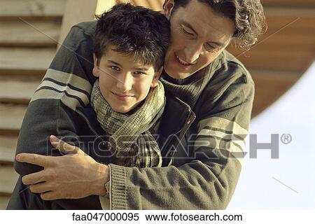 Stock Photography - Father embracing son, boy smiling at camera. Fotosearch