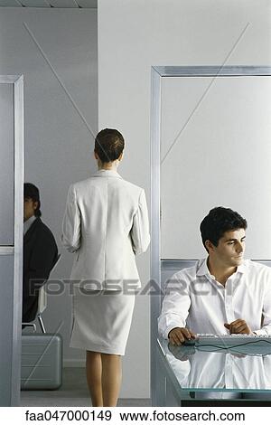 Female executive walking through office while colleagues work, rear view View Large Photo Image Stock Photo - Female executive walking through office while colleagues work, rear view. Fotosearch