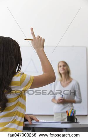 Female high school student raising hand in class View Large Photo Image Stock Photo - Female high school student raising hand in class. Fotosearch