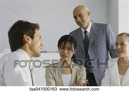Four business associates having conversation, smiling View Large Photo Image Stock Image - Four business associates having conversation, smiling. Fotosearch