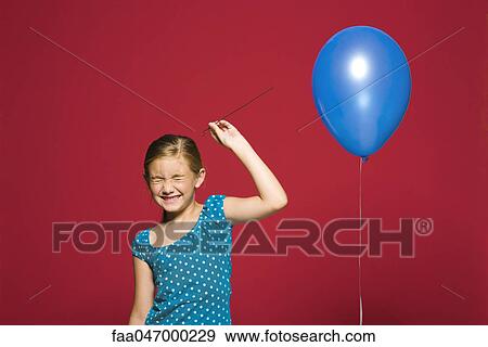 Stock Photo - Girl preparing to pop balloon. Fotosearch