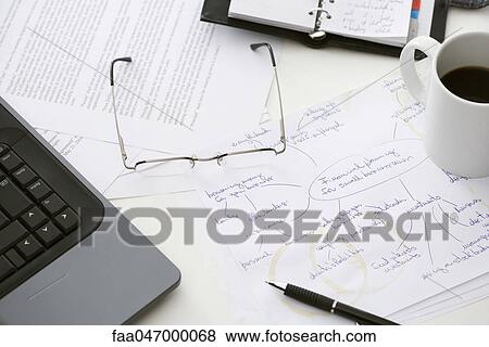 Stock Photo - Hand written business plan on cluttered desk. Fotosearch