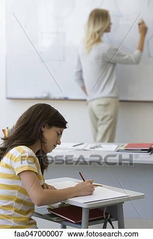High school student taking notes as teacher writes on whiteboard View Large Photo Image Stock Photo - High school student taking notes as teacher writes on whiteboard. Fotosearch