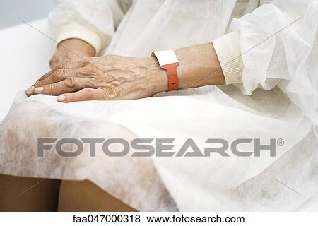 Stock Photo - Hospital patient waiting with hands in lap, cropped. Fotosearch