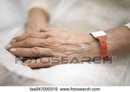 Hospital patient's hands folded in lap, close-up View Large Photo Image Stock Photo - Hospital patient's hands folded in lap, close-up. Fotosearch