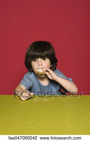 Stock Image - Little boy eating sandwich. Fotosearch