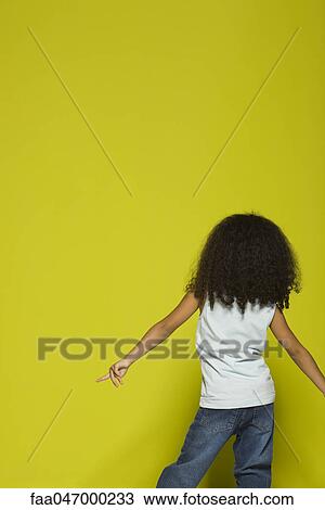 Stock Image - Little girl dancing, rear view. Fotosearch