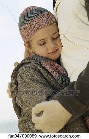 Stock Photo - Little girl embracing parent, looking down. Fotosearch