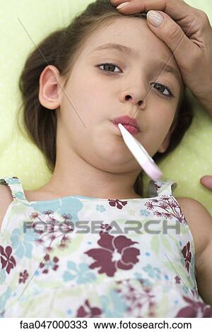 Little girl lying down with thermometer in mouth View Large Photo Image Stock Image - Little girl lying down with thermometer in mouth. Fotosearch