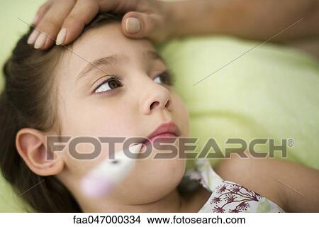 Little girl with fever, thermometer in mouth View Large Photo Image Picture - Little girl with fever, thermometer in mouth. Fotosearch