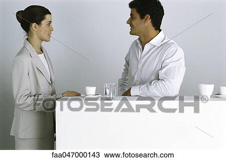 Stock Image - Male and female colleagues having coffee break together. Fotosearch