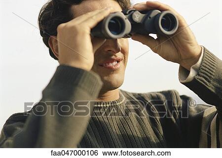 Man looking through binoculars View Large Photo Image Stock Photograph - Man looking through binoculars. Fotosearch