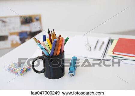 Markers, pens and pencils in mug on desk with school supplies View Large Photo Image Stock Photo - Markers, pens and pencils in mug on desk with school supplies. Fotosearch