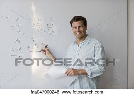 Stock Photo - Math teacher pointing to arithmetic on whiteboard. Fotosearch