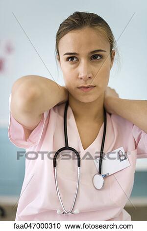 Stock Image - Nurse massaging her neck. Fotosearch