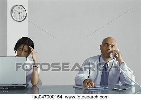 Picture - Office workers taking phone calls. Fotosearch
