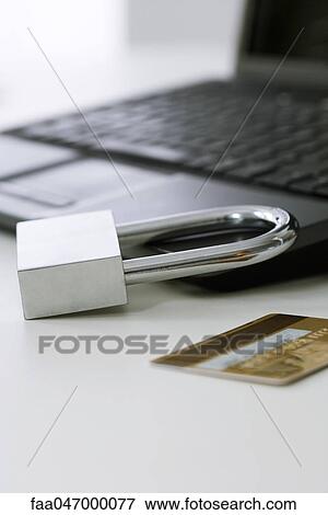 Padlock on laptop computer, credit card nearby View Large Photo Image Stock Photo - Padlock on laptop computer, credit card nearby. Fotosearch