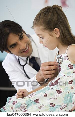 Pediatrician listening to little girl's chest with stethoscope View Large Photo Image Picture - Pediatrician listening to little girl's chest with stethoscope. Fotosearch